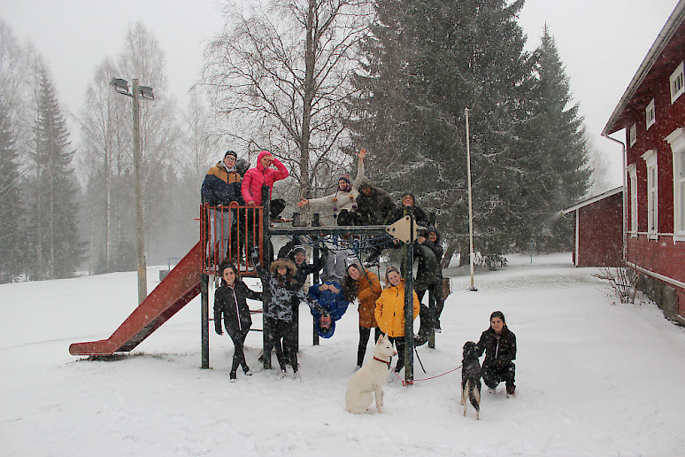 Kansainvälinen nuorisoryhmä kiipeilytelineellä talvisessa nuorisokeskuksessa.